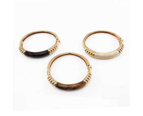 Set of Three Vintage 14 Karat Yellow Gold Bangle Bracelets set with Tiger-eye, Black Onyx and Ivory. Stamped 14K. Good vintag