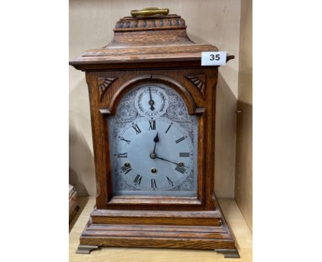 An early 20th C oak cased chiming bracket clock, H. 48cm. Appears to be in working order.