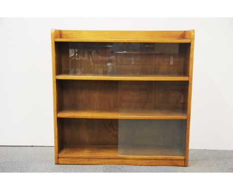 A mid 20th Century light oak bookcase with sliding glass doors, W. 91cm. H. 92cm.
