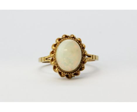 A hallmarked 9ct yellow gold ring set with a cabochon cut opal, (O.5).