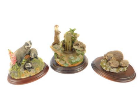 A Country Artists sculpture modelled as an Otter with waterfall, CA568, together with two Border Fine Arts sculptures modelle