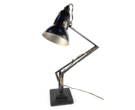 A black angle poise table lamp, raised on a stepped square base, 77cm H extended