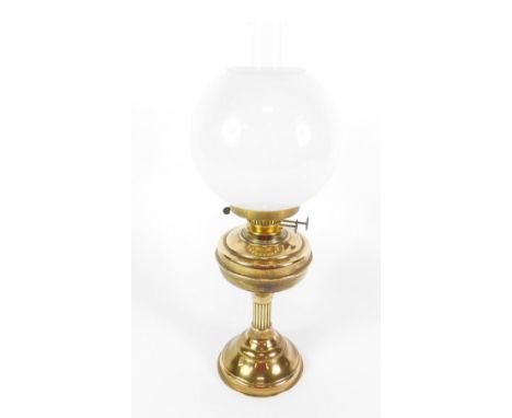 An early 20thC brass oil lamp, with chimney and white glass circular shade, 56cm H.