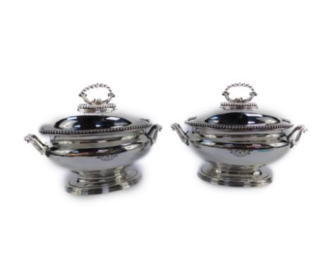 A pair of Victorian silver plated sauce tureens and covers, of baluster form with gadrooned rims, the lid engraved with a cre