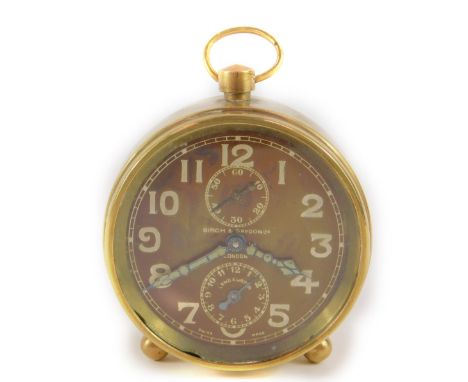 A Birch &amp; Gaydon Ltd WWI period travel alarm clock, brass cased with circular faux wood dial bearing Arabic numerals, sub