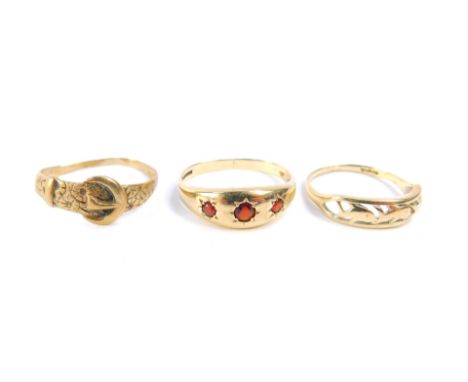 A 9ct gold and garnet three stone gypsy ring, size S, 9ct gold belt and buckle ring, and a 9ct gold band decorated with a pie