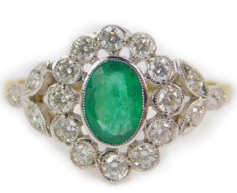 A Georgian style emerald and diamond ring, in a floral design, set in yellow metal stamped 18ct, the oval cut emerald approx 