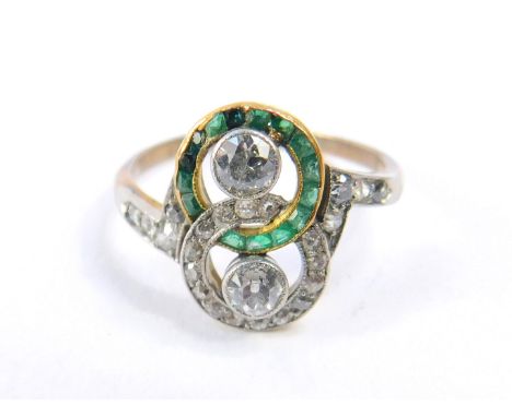 An Edwardian emerald and diamond ring, in a double entwined circular link design, set in white and yellow metal, diamonds app