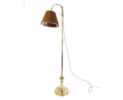 A brass telescopic standard lamp, with up and over shade, raised on a circular base, 152cm H.