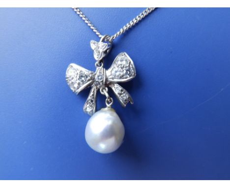 A diamond set white metal ribbon pendant with grey pearl swing on white '750' fine necklace chain.