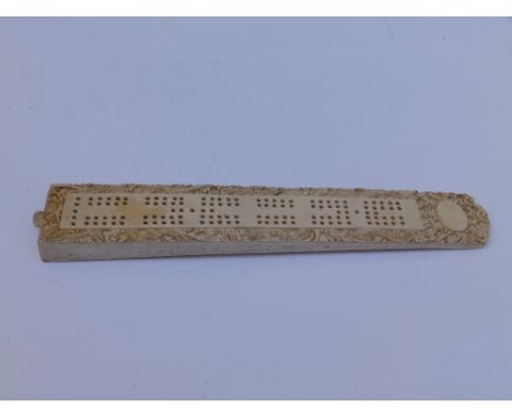A 19thC Chinese carved ivory cribbage board, decorated with dragons to borders,  9.25".