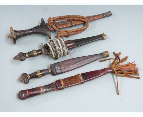 Four African tribal daggers, each with leather scabbard and shaped handle, longest 31cm