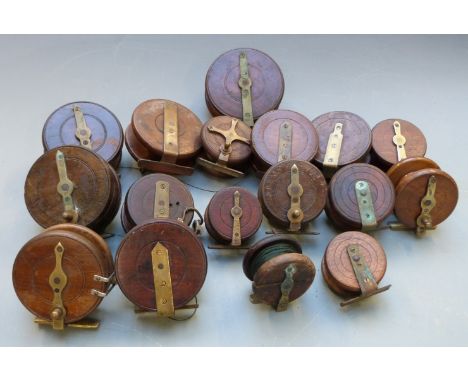 Seventeem vintage wooden and brass fishing reels, largest diameter 12cm