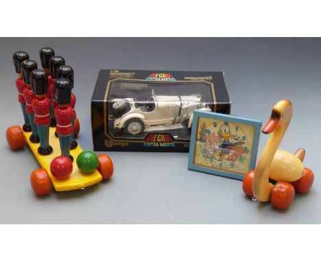 A collection of children's toys comprising Donald Duck Glen Clock animated clock with nodding head, two vintage wooden toys, 