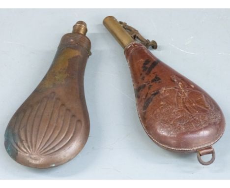 A copper and brass powder flask with embossed decoration to both sides together with a leather and brass shot flask with embo