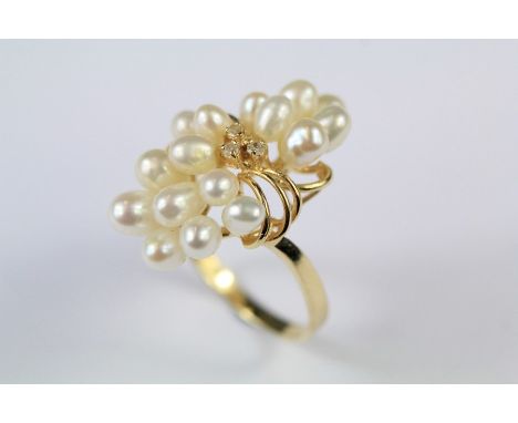 A Continental 14ct Yellow Gold and Seed Pearl Floral Ring. The ring set with three diamonds approx 3pts, size L, approx 5gms.