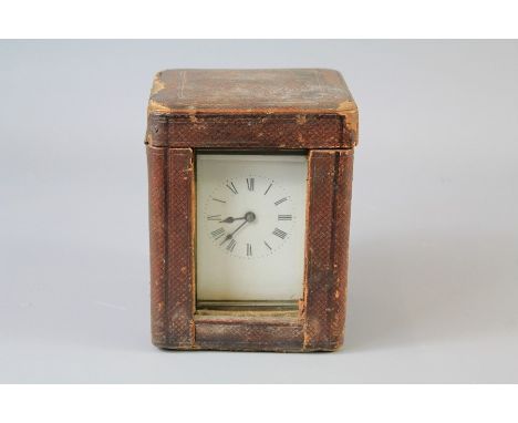 An Antique Brass Carriage Clock. The clock with SF movement, white enamel face with Roman dial, approx 12 x 8 cms, contained 