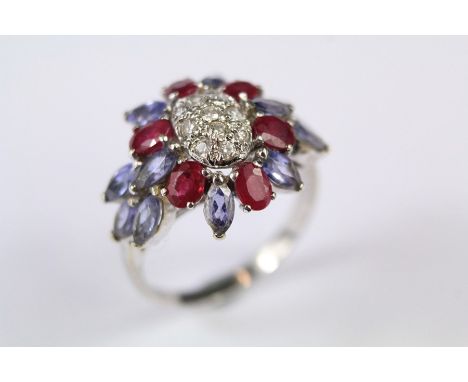 An 18ct White Gold Ruby, Diamond and Sapphire Ring. The ring set with approx twelve marquise-cut sapphires approx 5 x 2 mm ea