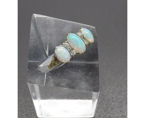 Opal and diamond claw set dress ring, with three oval opals and six round-cut diamonds set in yellow gold, ring size T