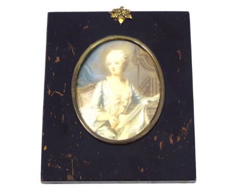 English School - half length portrait of a seated lady reading a book, indistinctly signed, work on ivory, oval mount, 3.25" 