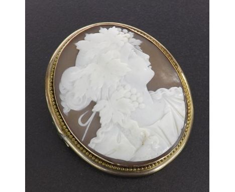 Victorian oval shell cameo brooch depicting a portrait of a lady with fruiting vine headdress within a beaded yellow gold mou