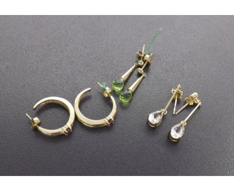 Three pairs of gold gem set earrings to include ruby hoops, peridot drops and pink topaz