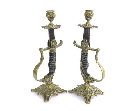 Interesting pair of novelty candlesticks composed from officer sword hilts, with lion heads with ruby glass eyes, 12" high (2