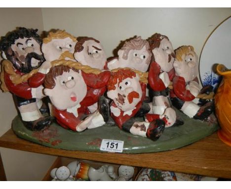 A hand made ceramic tug 'o' war figure group. 1 arm a/f and some chips to paint