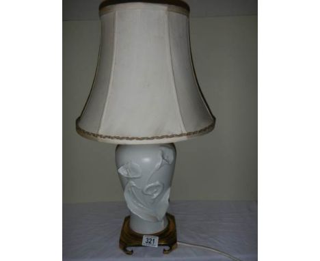 A white ceramic table lamp with brass base