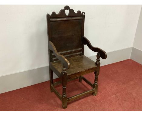 A XVII Century Joined Oak Armchair, the shaped top rail with pierced heart, panelled back, shaped arms and later oak seat, on