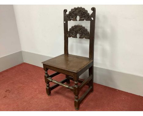 A XVII Century Joined Oak Chair, with carved finials, shaped and carved top and centre rails, solid seat on turned and block 