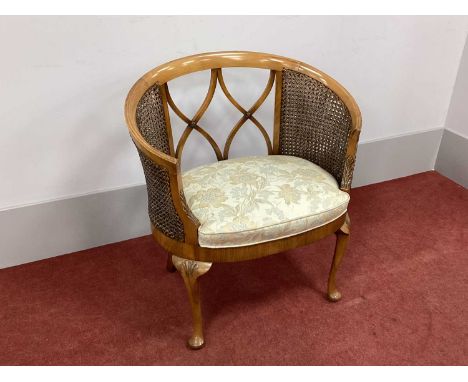 A XX Century Walnut Bergére Tub Chair, with 'X' shaped double caned sides, upholstered seat on cabriole legs with pad feet.