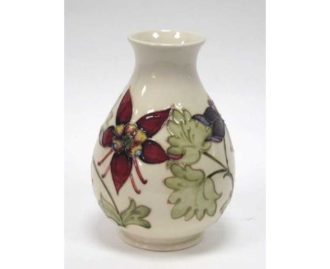 A Moorcroft Pottery Vase, of inverted pear shape, painted in the 'Columbine' pattern with red/purple flowers against an ivory