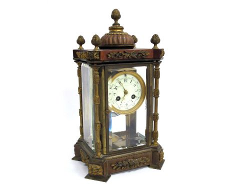 An Early XX Century French Mantle Clock, in a glazed mahogany and ormolu case with domed top with artichoke finials and folia