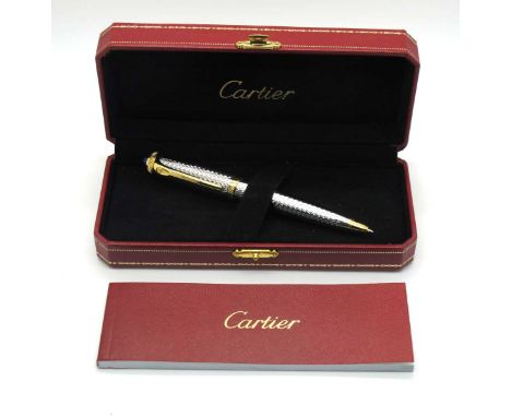 A Cartier Ballpoint Pen, in an engine turned white metal and gilt case inset with a blue stone to the top, 14.5cm long, cased