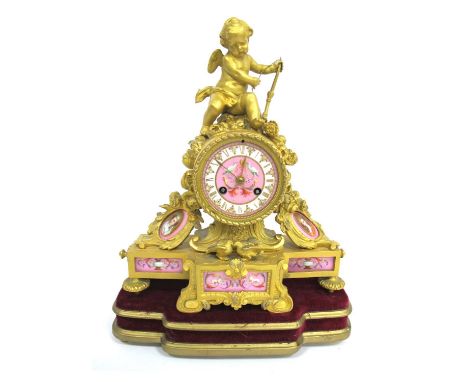 A Late XIX Century French Ormolu Mantle Clock, inset with pink porcelain panels painted with portraits and urns, the circular