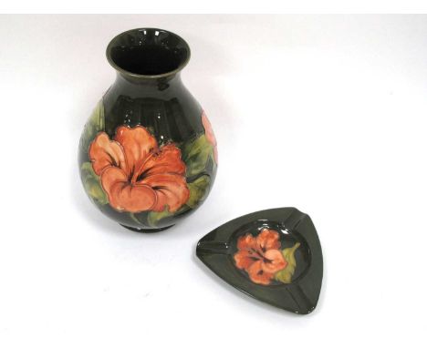 A Moorcroft Pottery Vase, of pear shape, painted in the 'Coral Hibiscus' pattern against a green ground, impressed marks, 22c