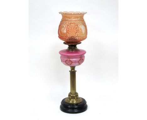 A Late Victorian Oil Lamp, with pink opaque glass reservoir, brass column and black base, later shade, 62cm high.