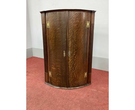 A Late XVIII Century Oak Bow Fronted Corner Cupboard, with reeded sides and three internal shelves.