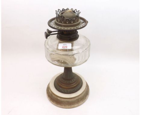 A 19th Century Oil Lamp with brass fittings, clear glass font, brass pedestal and a round ceramic base, lacking shade or chim
