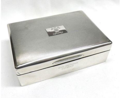 An Elizabeth II Silver Encased Cigarette Box, rectangular shaped, the engine-turned lid bearing a military style crest, the f