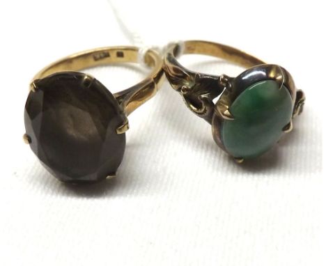 Unmarked yellow metal Jade panelled ring together with a mid-grade yellow metal Smokey Quartz ring stamped “14K” (2) 