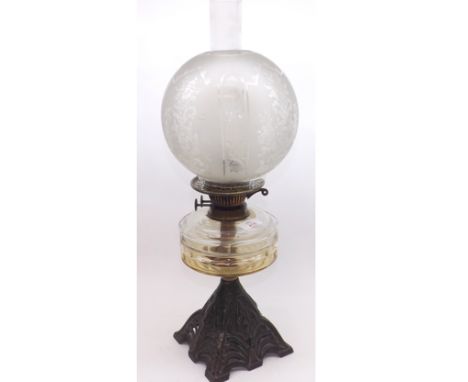 A Victorian Oil Lamp with clear glass chimney, frosted glass shade, clear glass font, raised on a cast iron floral decorated 