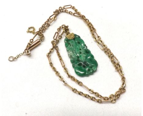 A small early/mid-20th Century Jade Pendant of shaped rectangular form, having pierced and carved decoration on a yellow meta