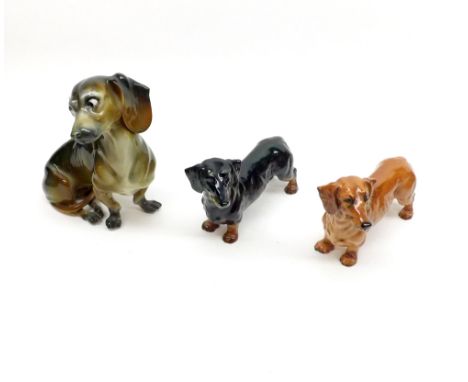 A Mixed Lot comprising: two Royal Doulton Model Dachshunds; together with a further Continental Model Dachshund, and two Goeb