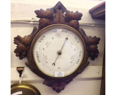 A late 19th Century Carved Oak Aneroid Barometer, the diamond-shaped case with carved fruiting vine detail to a spun brass be