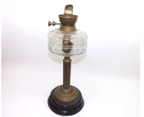 A Victorian Oil Lamp with brass fittings, clear glass font, brass column and a circular metal base, (lacks chimney or shade),