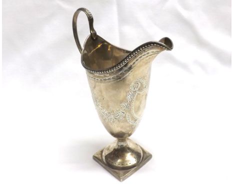 A George III Silver Helmet Cream Jug with bright cut garland decoration, beaded rim, beaded looped handle and loaded square b