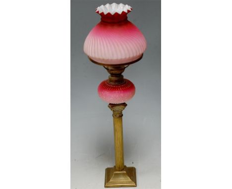 A Victorian oil lamp, having filled cranberry glass shade and reservoir on brass Corinthian column base  Condition Report / E