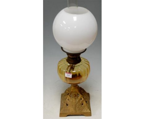 An early 20th century oil lamp having an opalescent globular shade, glass reservoir and cast iron base